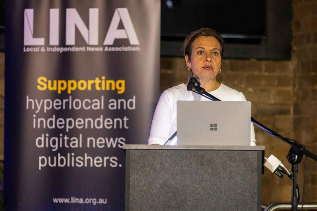 Michelle Rowland speaks at the LINA Summit 2023 at a lectern in front of a LINA banner with the text 'Supporting hyperlocal and independent news'.